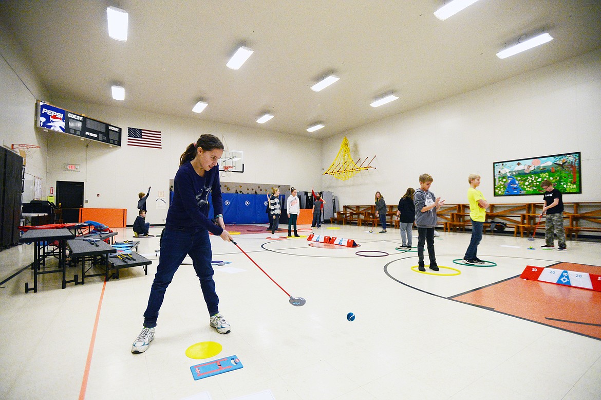 Sixth-grader Madolynn Bowman works on her putting skills during a golf program at Creston School on Wednesday, Dec. 11. (Casey Kreider/Daily Inter Lake)