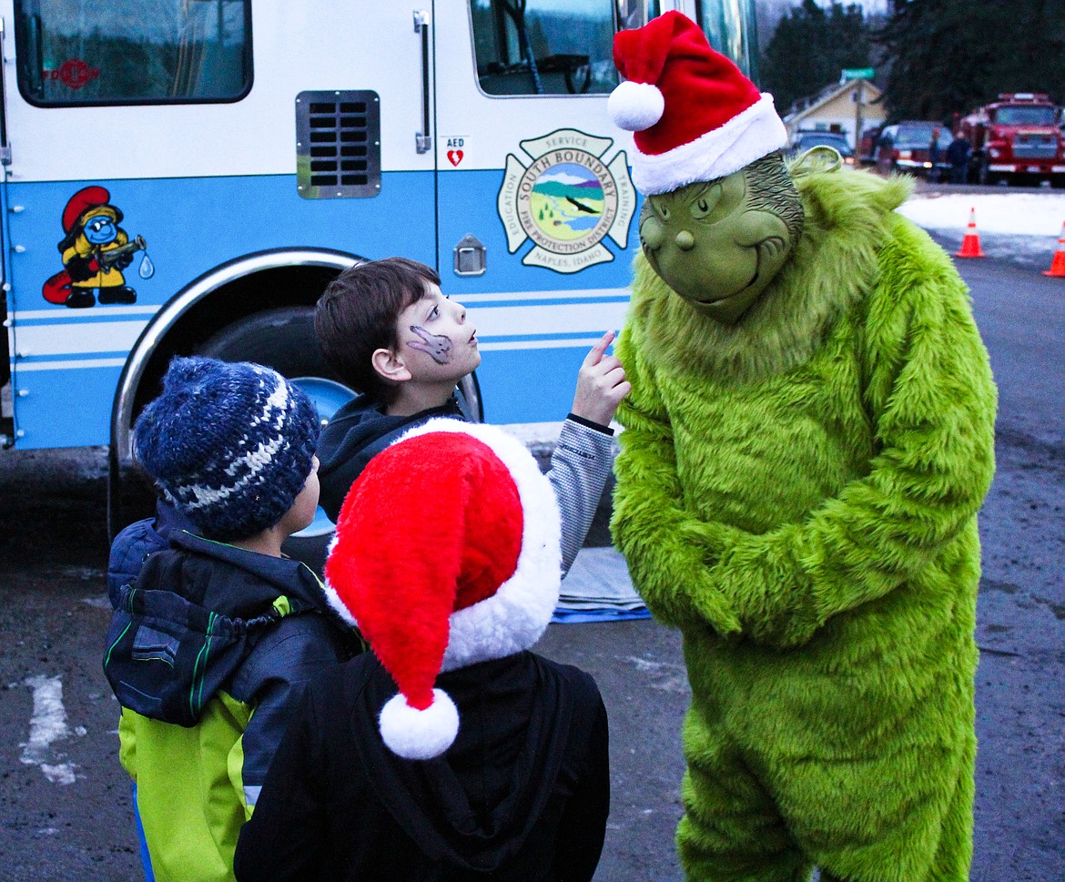 Photos by TONIA BROOKS
The Grinch gets a firm talking to from youngsters attending the Naples Holiday Festival on Saturday, Dec. 14.