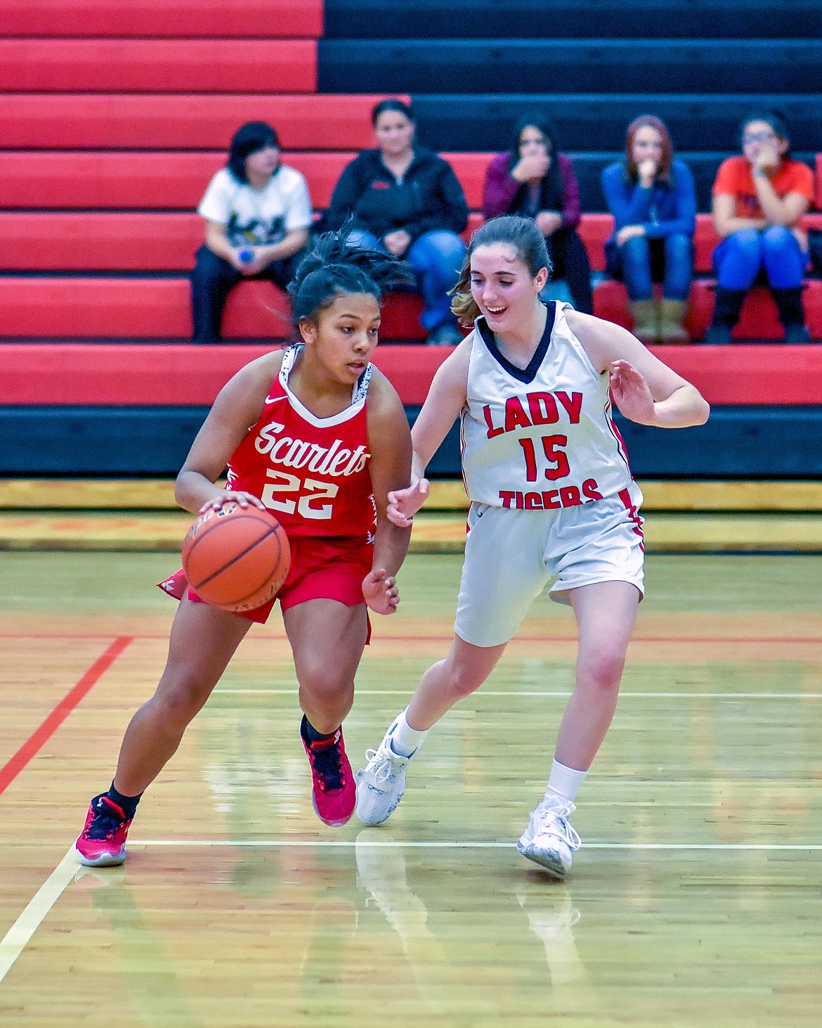 Arlee Scarlet freshman Princess Bolen (22) dribbles up the court against defensive pressure applied by a Darby Lady Tiger at the Western C Tip-Off. (Photo courtesy of Christa Umphrey, Forward Photography)