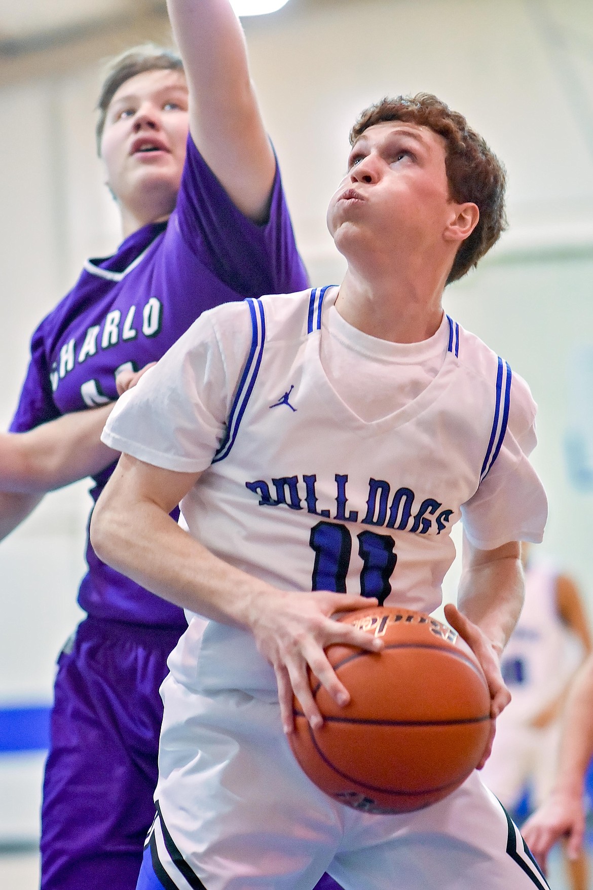 Mission Bulldog senior guard Joe Stults (11) eyes a field goal attempt, while Charlo Viking senior Bowen Tryon (41) defends. (Photo courtesy of Christa Umphrey, Forward Photography)