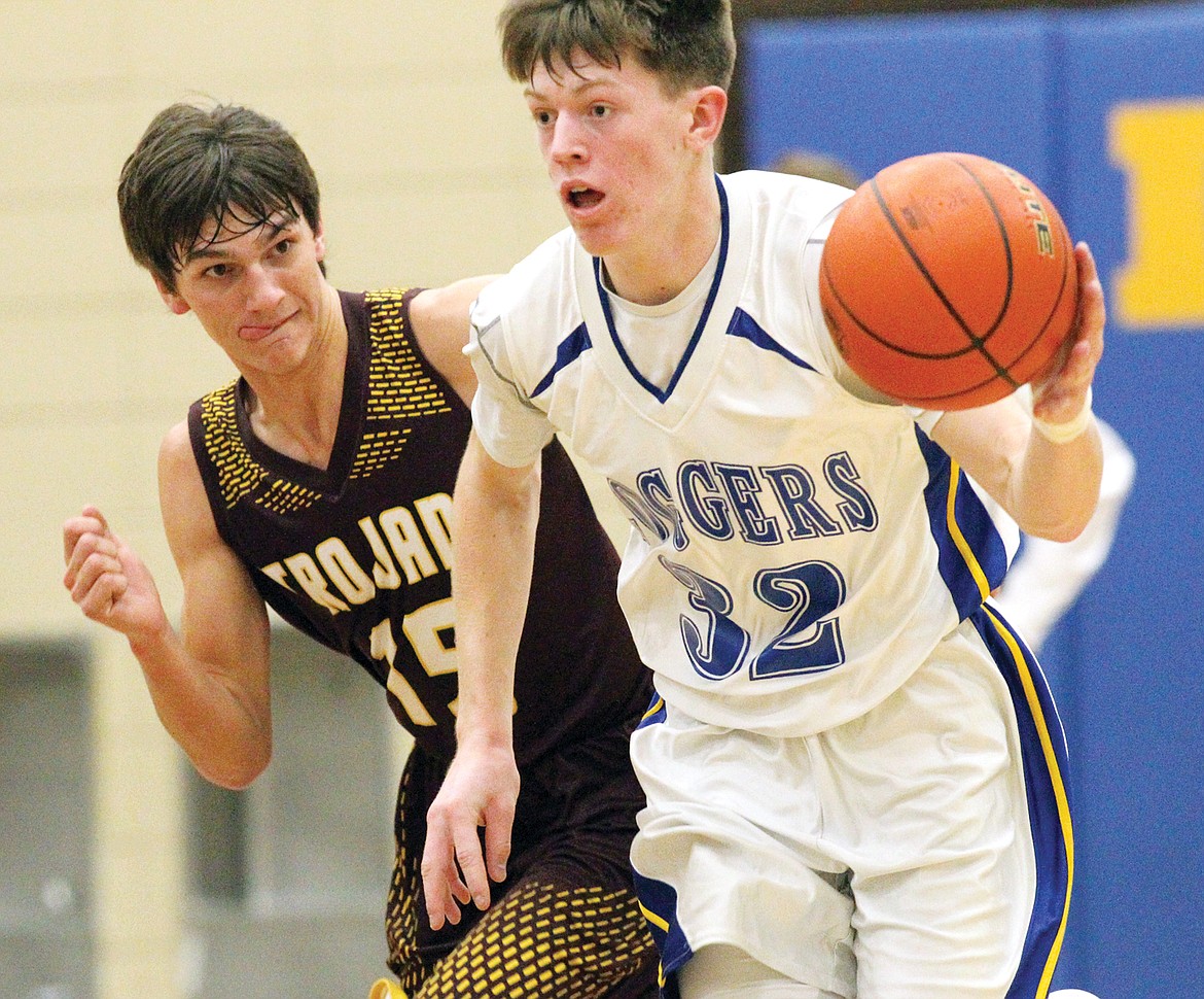 Sophomore guard Caden Williams brings the ball down court in second quarter with Troy's Moxley Roesler-Begalke in pursuit. Loggers over Trojans 59-15. (Paul Sievers/The Western News)