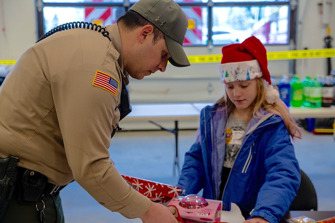 Photo by HEATHER COWAN
Shoshone County Sheriff&#146;s Office deputy Dameon Groves helps wraps some presents.