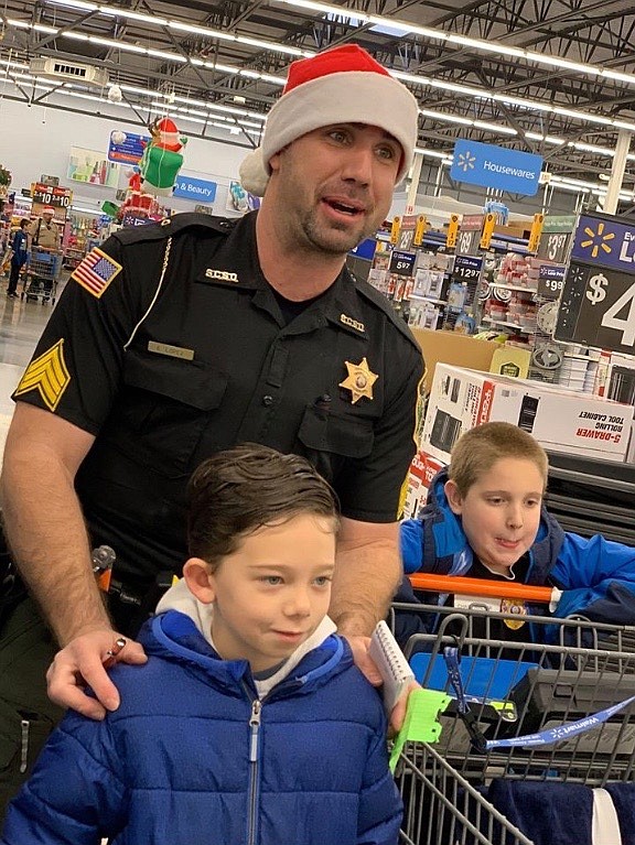 Photo by HEATHER COWAN
Shoshone County Sheriff&#146;s Office jail Sgt. Eli Lopez heads to checkout with his shopping partners.