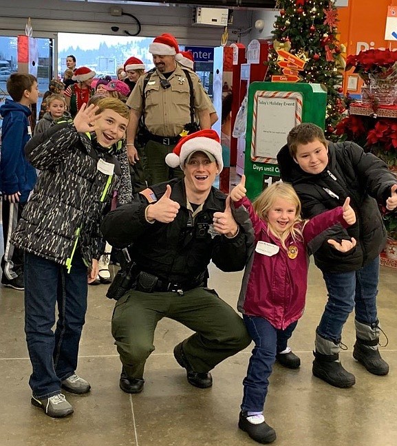 Shoshone County Sheriff&#146;s Office deputy William Keller smiles with some participating kids just as they walk into Walmart to shop.