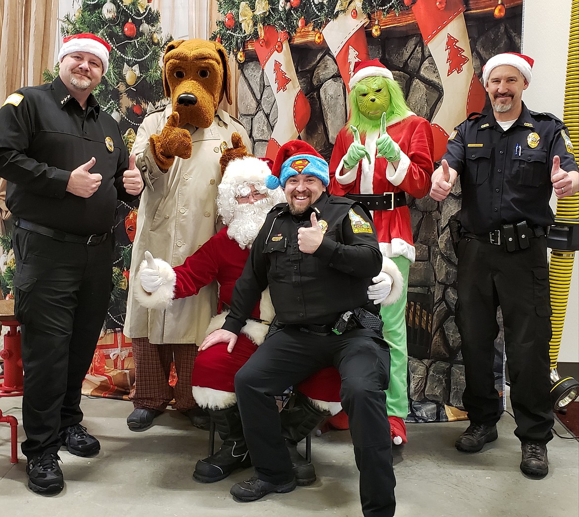 Photo by HEATHER COWAN
Osburn Police Chief Darrel Braaten, officer Jason Woody and reserve officer Corey Thompson pose with the events special guests &#151; McGruff the Crime Dog, Santa and the Grinch.