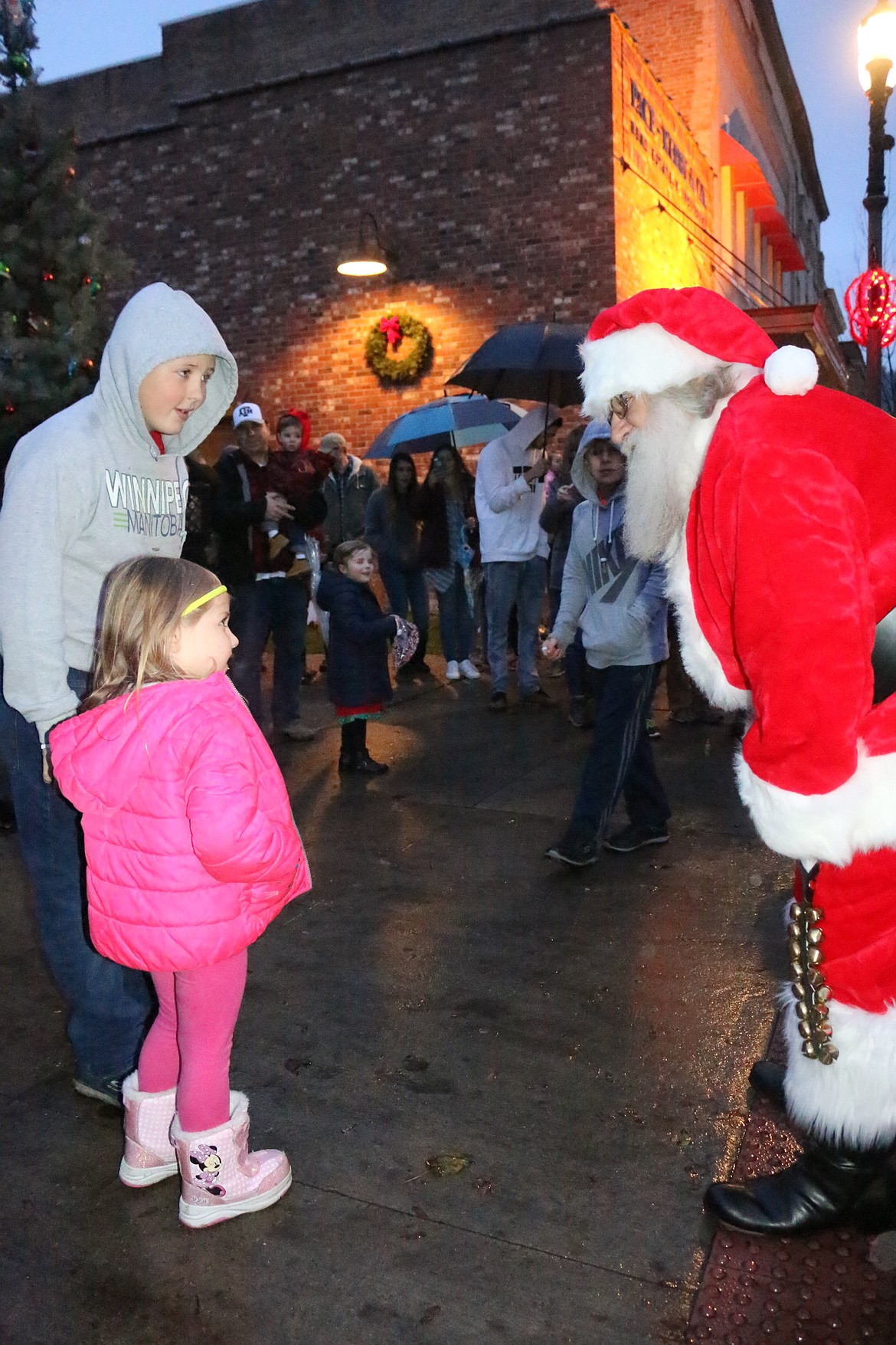 Photo by MANDI BATEMAN
Santa Claus greeting children in the rain.