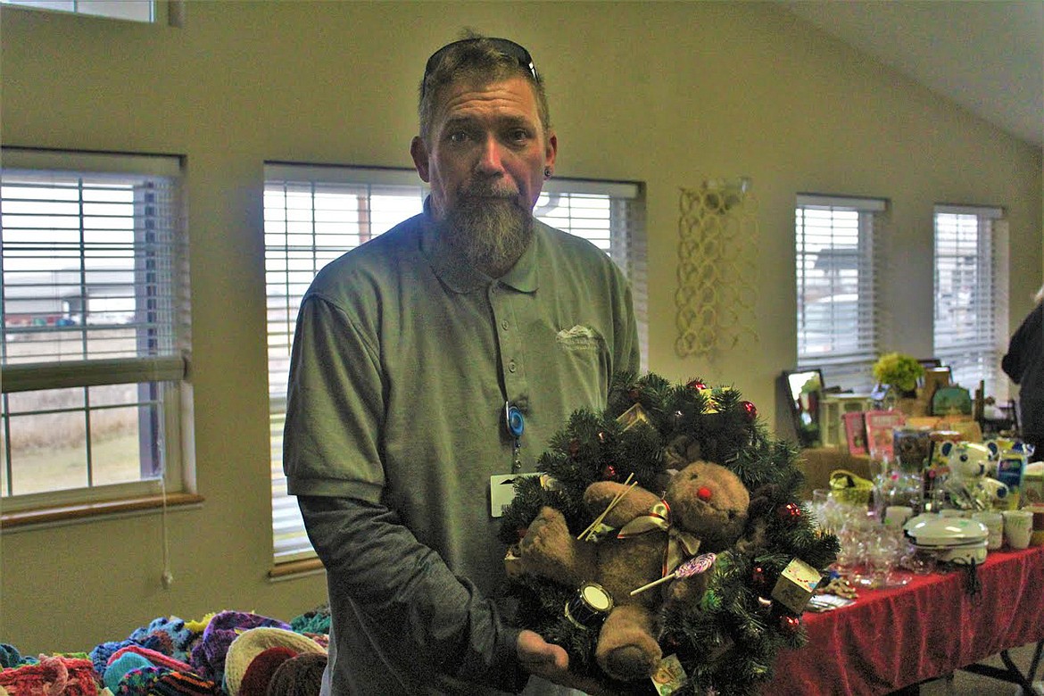 Del Smith displays one of many wreaths donated to the bazaar by thecommunity last Thursday morning. (John Dowd/Clark Fork Valley Press)