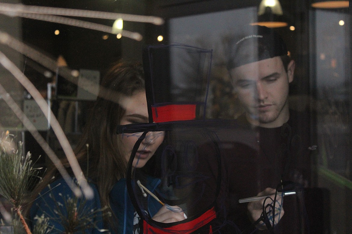 Skylar Bergstrom and Nathan McNulty work on a snowman for the entry window of the Bistro in downtown Plains last Thursday. (John Dowd/Clark Fork Valley Press)