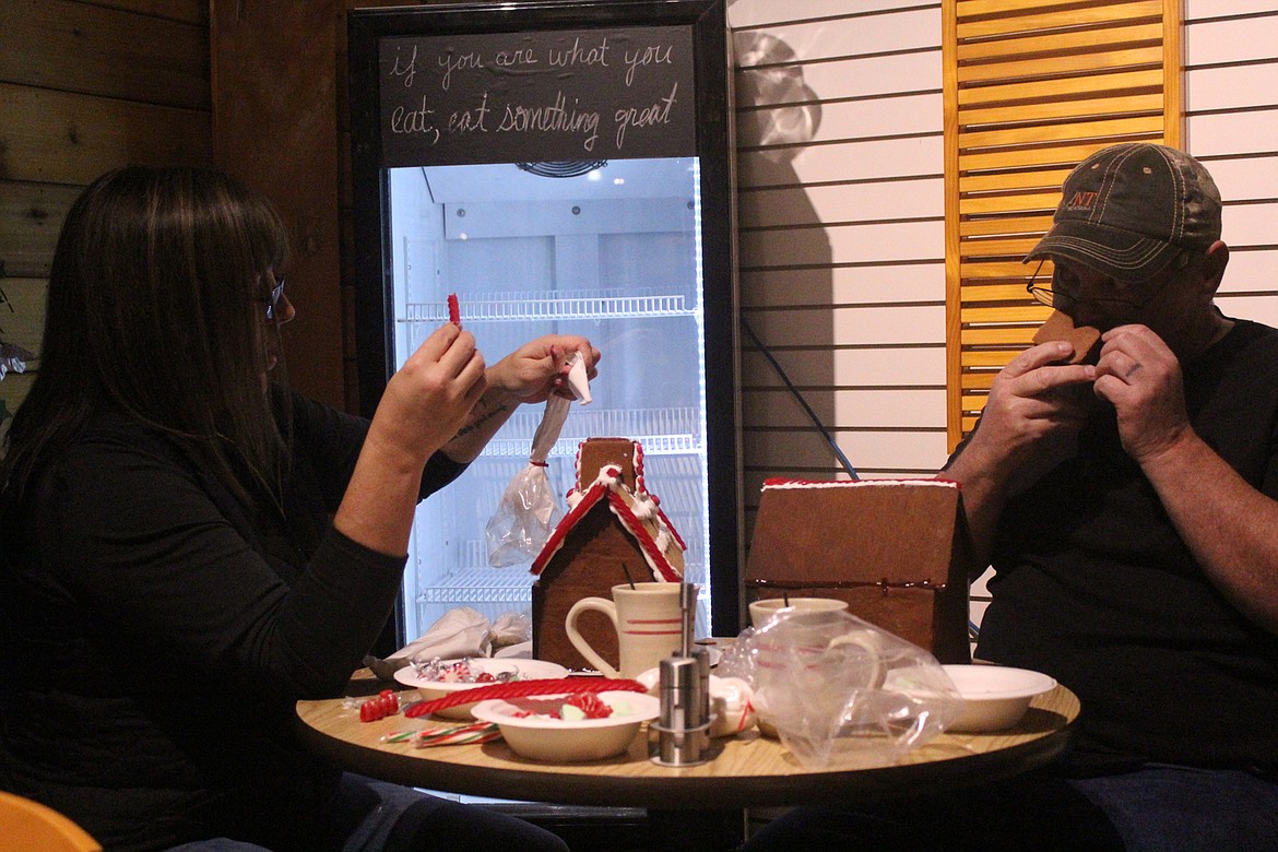 Husband and wife, Tracey and Angela Muse, work on their gingerbread houses, hoping to crush their competition this year, last Friday night. (John Dowd/Clark Fork Valley Press)