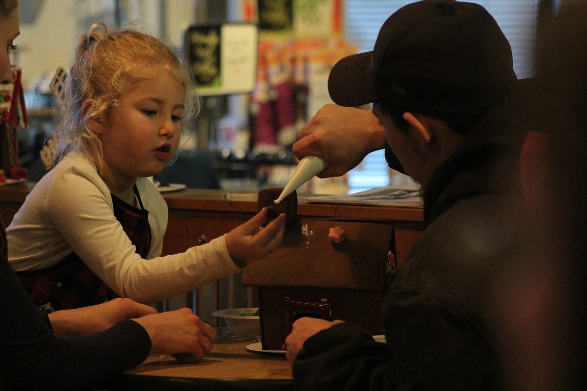 Darin Anderson and his daughter Ivy, work on her gingerbread house, last Saturday afternoon. (John Dowd/Clark Fork Valley Press)