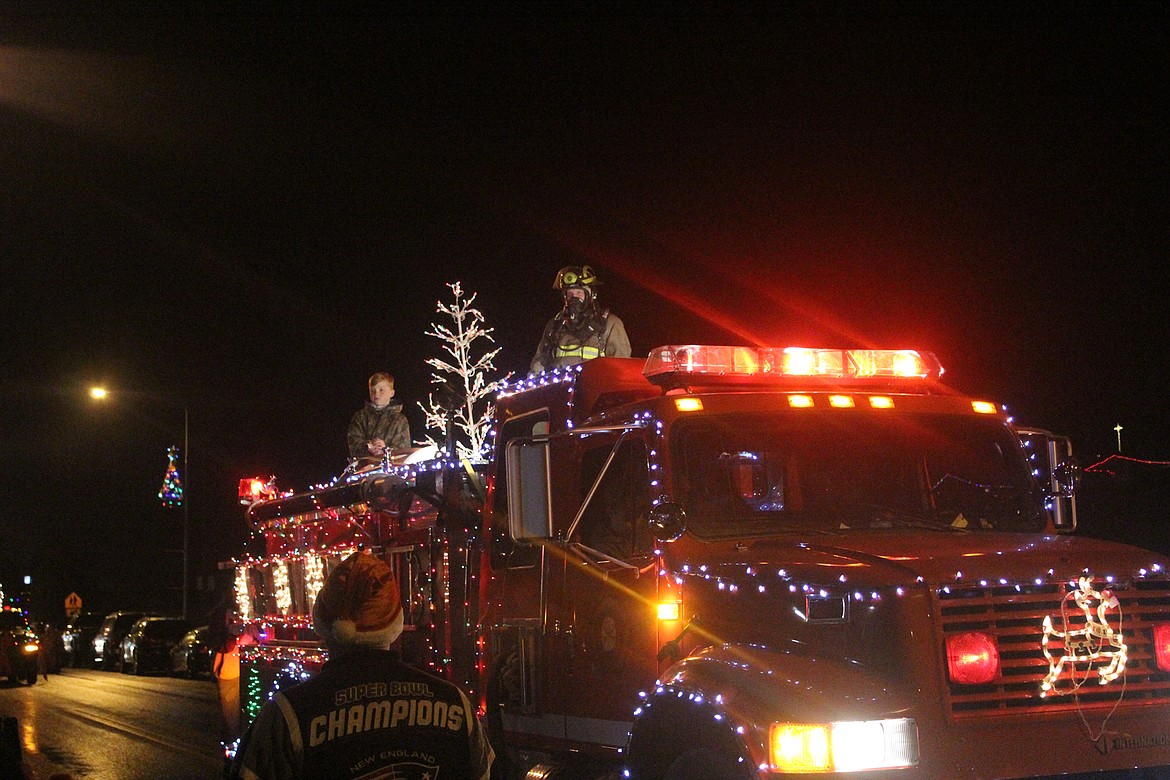 Members of the Thompson Falls Fire Department throws candy at the Thompson Falls Christmas parade Saturday night. (John Dowd/Clark Fork Valley Press)