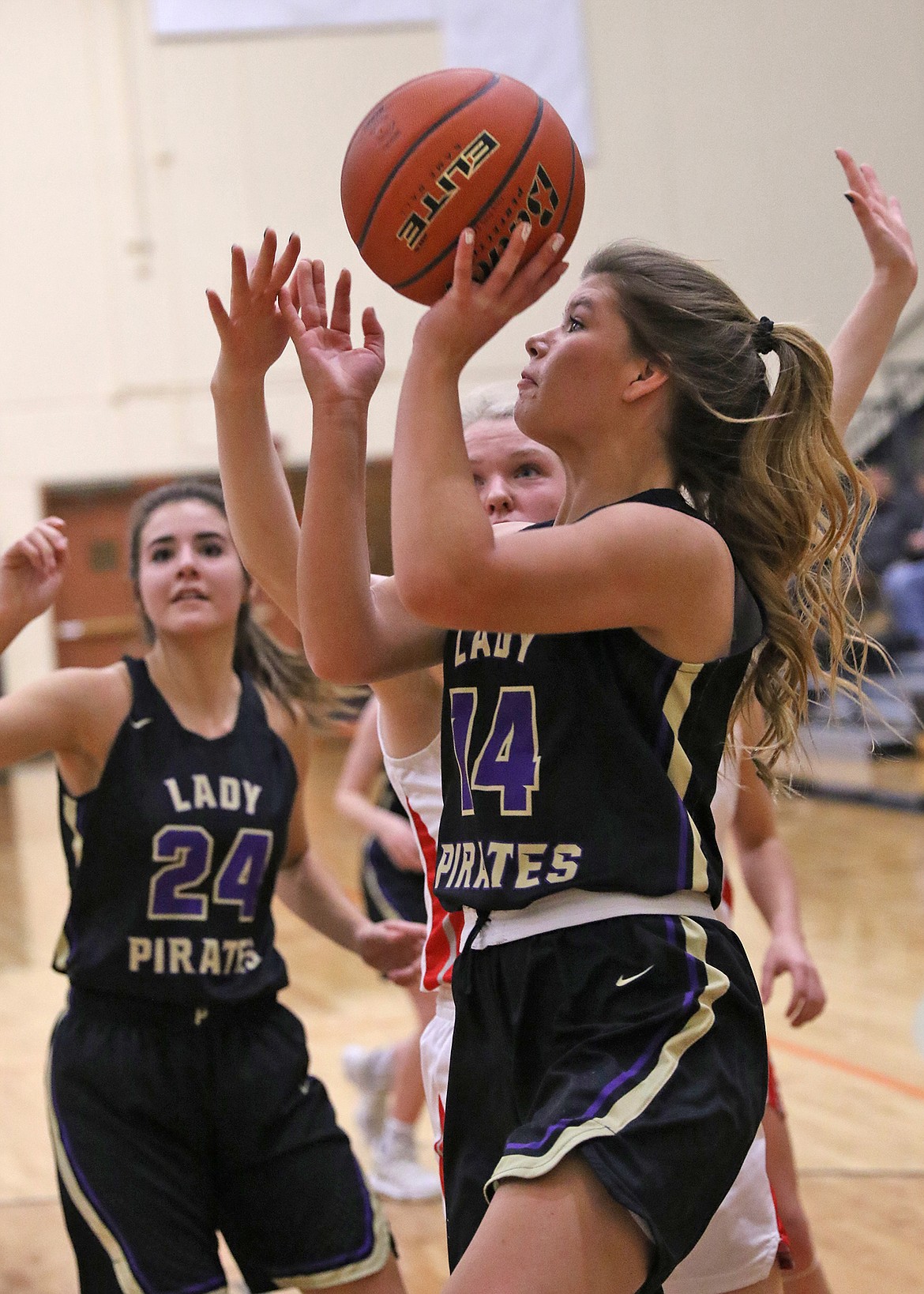 Lady Pirate sophomore forward Gianna Fyant drives for two points while Polson's Misty Tenas (24) looks on against Glendive at the tip-off tournament in Frenchtown Saturday. (Photo by Bob Gunderson)