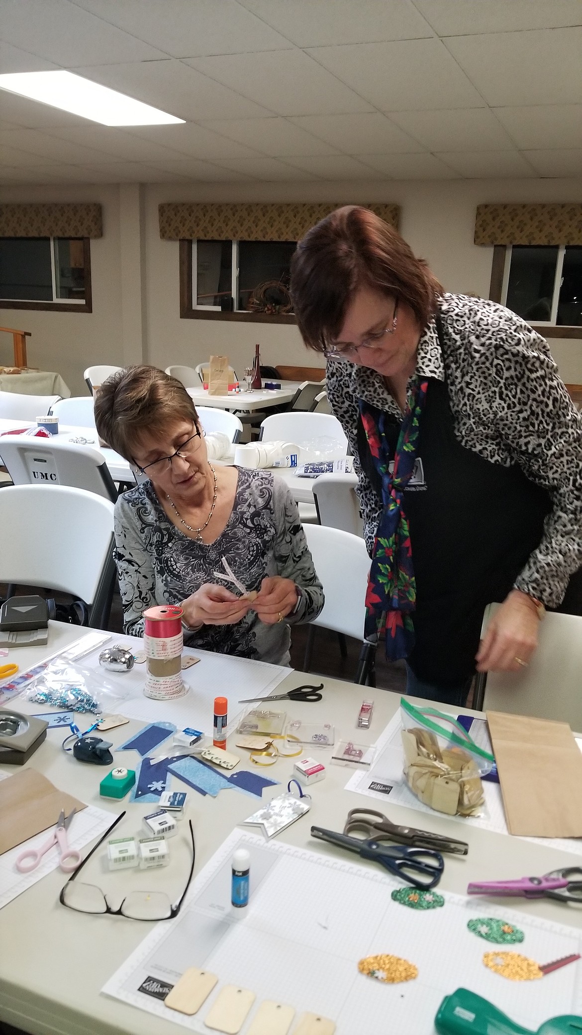 Photo by MANDI BATEMAN
Cyndi Clark helps out one of the participants at the Holiday Papercrafting Make &amp; Take.