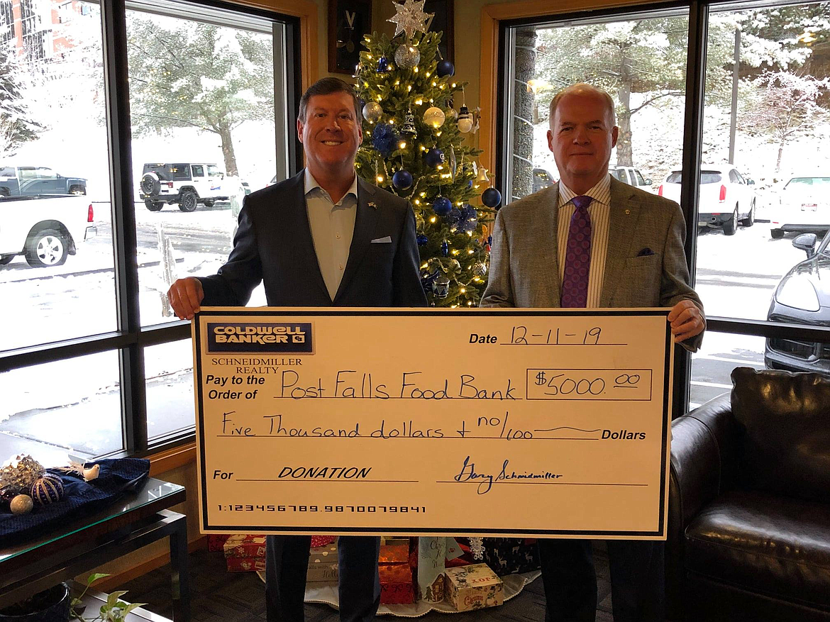 Coldwell Banker Schneidmiller Realty recently donated a total of $15,000 to the Coeur d'Alene, Post Falls and Rathdrum Food Banks. Pictured here are Mark Johnson and Gary Schneidmiller of Coldwell Banker Schneidmiller Realty with the $5,000 check to Post Falls Food Bank.