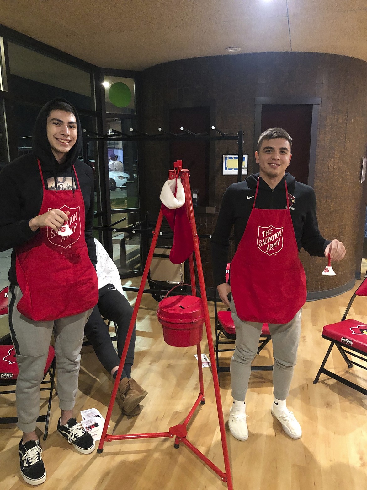 Teammates from NIC men&#146;s and women&#146;s soccer, men&#146;s and women&#146;s basketball, volleyball, and softball braved the elements since Nov. 22 at various ked kettle spots such as Super 1 Foods, Fred Meyer and Walmart. NIC basketball players Emmit Taylor III (left) and Tyler Tanner work the Salvation Army red kettles during an NIC wrestling dual in November. (Courtesy photos)