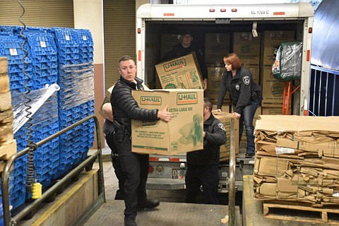 Courtesy of Mario Rios/CDA PD
Detective Joseph Scholten (left) and Officer Crystal Shaw (right) were two of 16 members of the Coeur d&#146;Alene Police Department to help deliver at least 75 boxes to Sacred Heart Monday. The department will continue its tradition Wednesday at Kootenai Health, where it will deliver gifts to hospitalized children on Christmas Day.