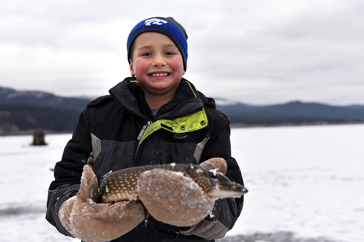 Tres Johnson, of Columbia Falls, holds a northern pike he caught during the 49th annual Sunriser Lions ice fishing derby on Saturday. (Casey Kreider/Daily Inter Lake)