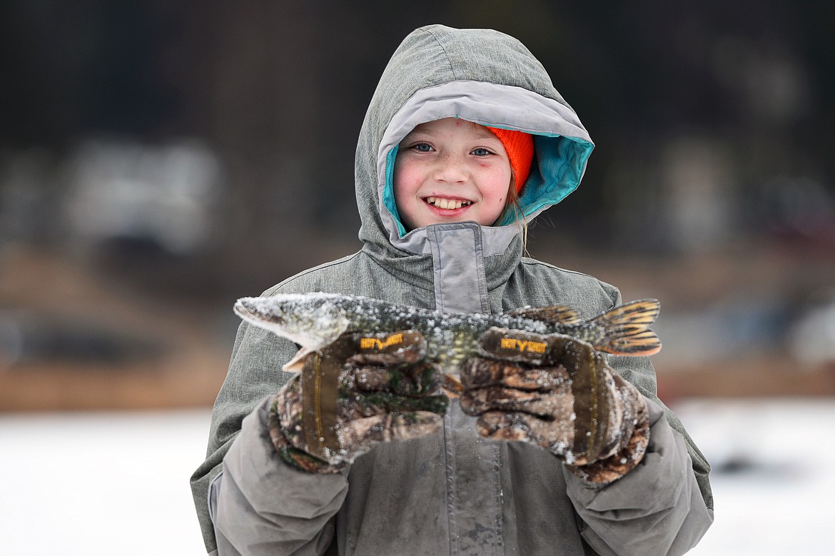Alona Johnson, of Columbia Falls, holds a northern pike she caught during the 49th annual Sunriser Lions ice fishing derby at Smith Lake on Saturday. (Casey Kreider/Daily Inter Lake)