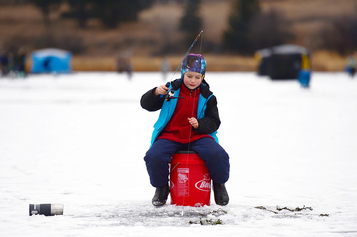 Finn Miller, of Whitefish, waits for a fish to bite at the 49th annual Sunriser Lions ice fishing derby at Smith Lake on Saturday. (Casey Kreider/Daily Inter Lake)