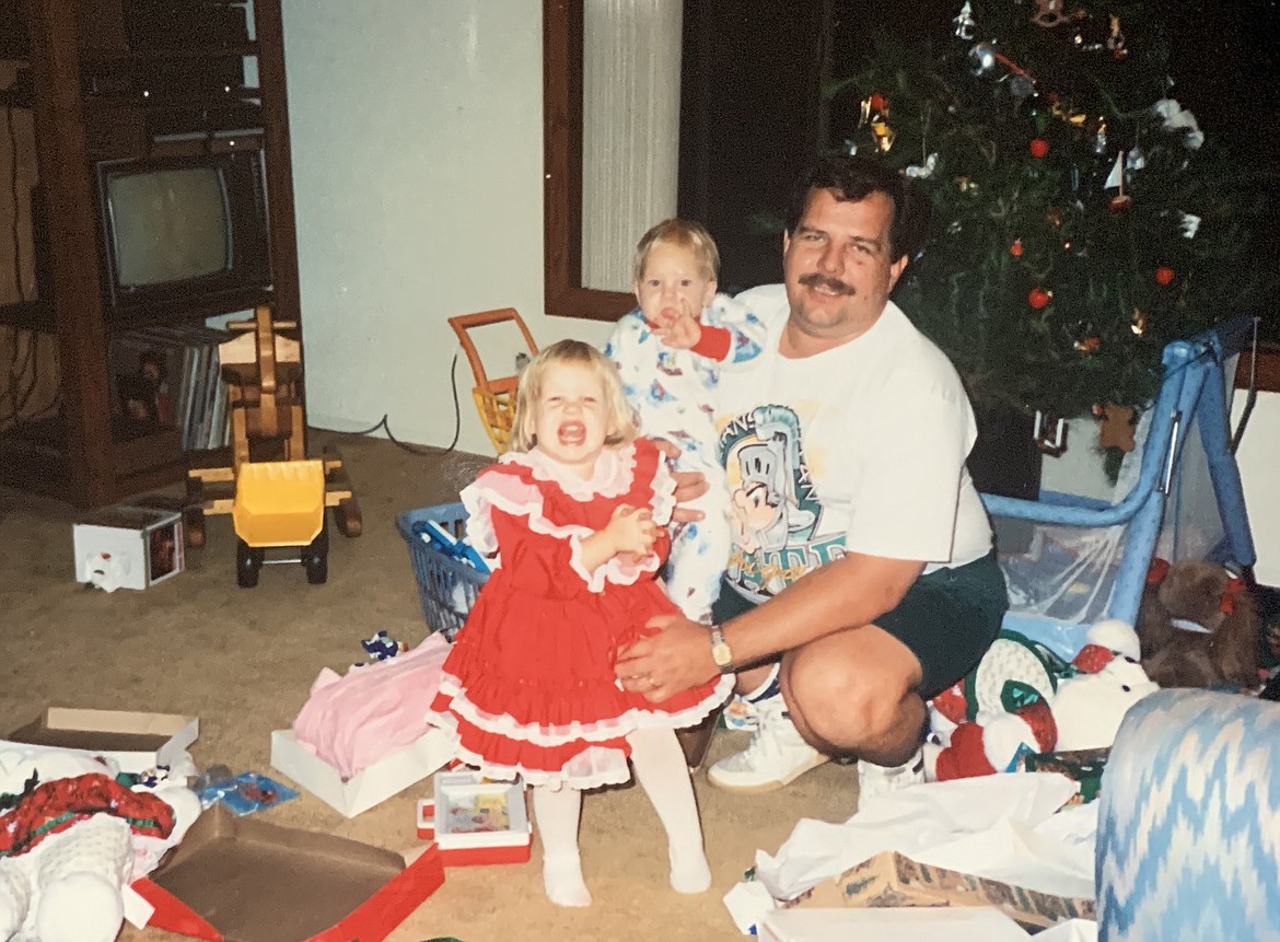 Mackenzie Reiss, left, her brother Lucas Reiss, and her dad, Rick Reiss pose for a picture on Christmas morning 1992.