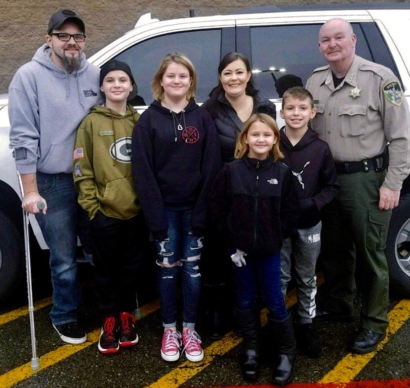Photo courtesy of the SHOSHONE COUNTY SHERIFF&#146;S OFFICE
Sheriff Mike Gunderson smiles for the camera with the Strange family after shopping with them.