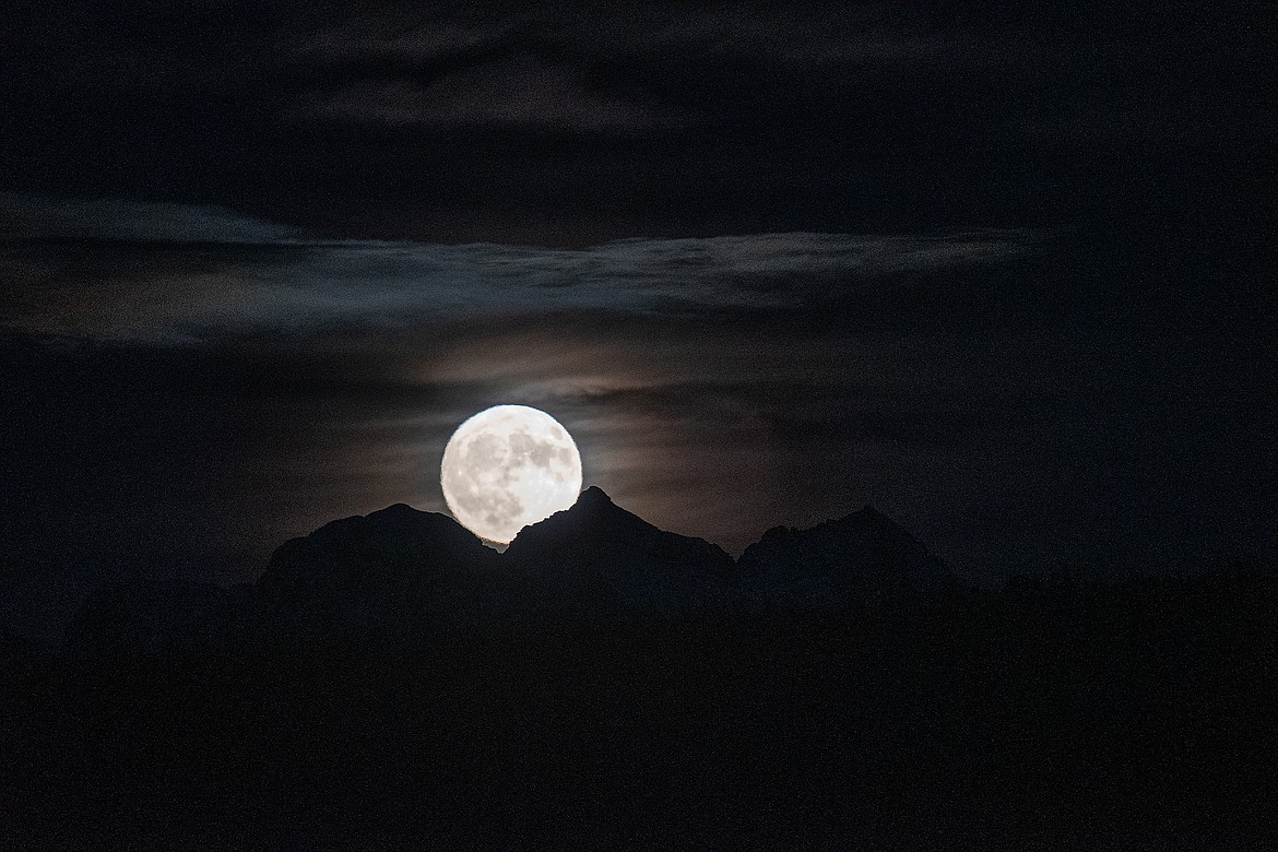 The nearly full moon rises over Glacier National Park Monday night.