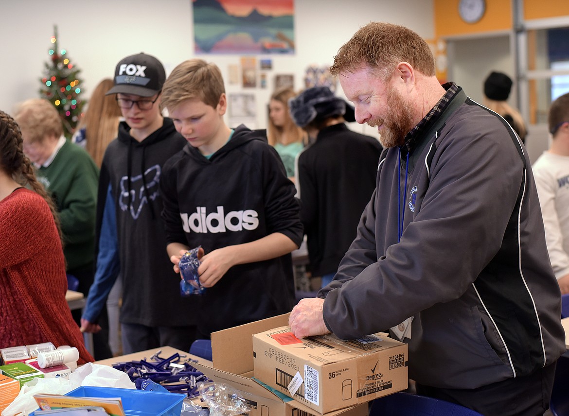 Sean Sullivan, right, the victim advocate for the Children&#146;s Advocacy Center and member of the Flathead County Human Trafficking Task Force, along with seventh- and eighth-graders at West Valley School, assemble of dignity bags on Friday for people in need or at risk of exploitation.