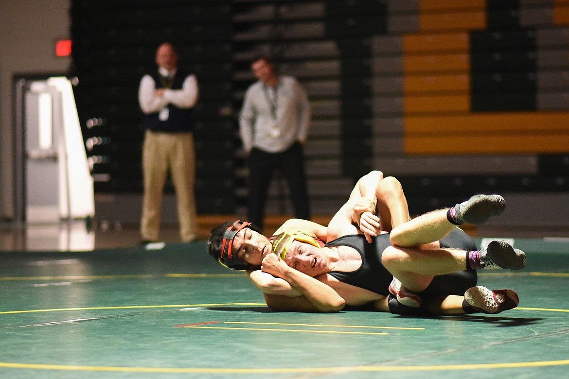 Bulldog Carter Moran fights off a Browning wrestler at a home triangular Tuesday, Dec. 17. (Daniel McKay/Whitefish Pilot)