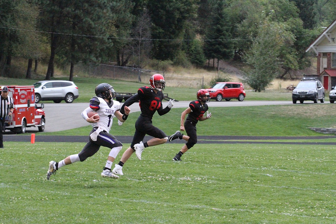 Photo by JOSH McDONALD
Mullan quarterback Caleb Ball runs toward the endzone as two Wallace defenders try to cut him off. Mullan won the game 74-0 in the first meeting between the two schools in seven years.