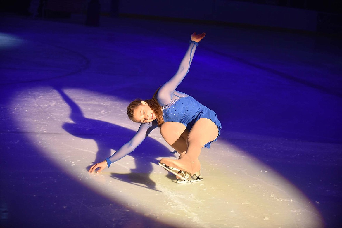 Muriel Mercer touches the ice while skating in the spotlight during the Glacier Skate Academy&#146;s Christmas on Ice show at Stumptown Ice Den. (Heidi Desch/Whitefish Pilot)