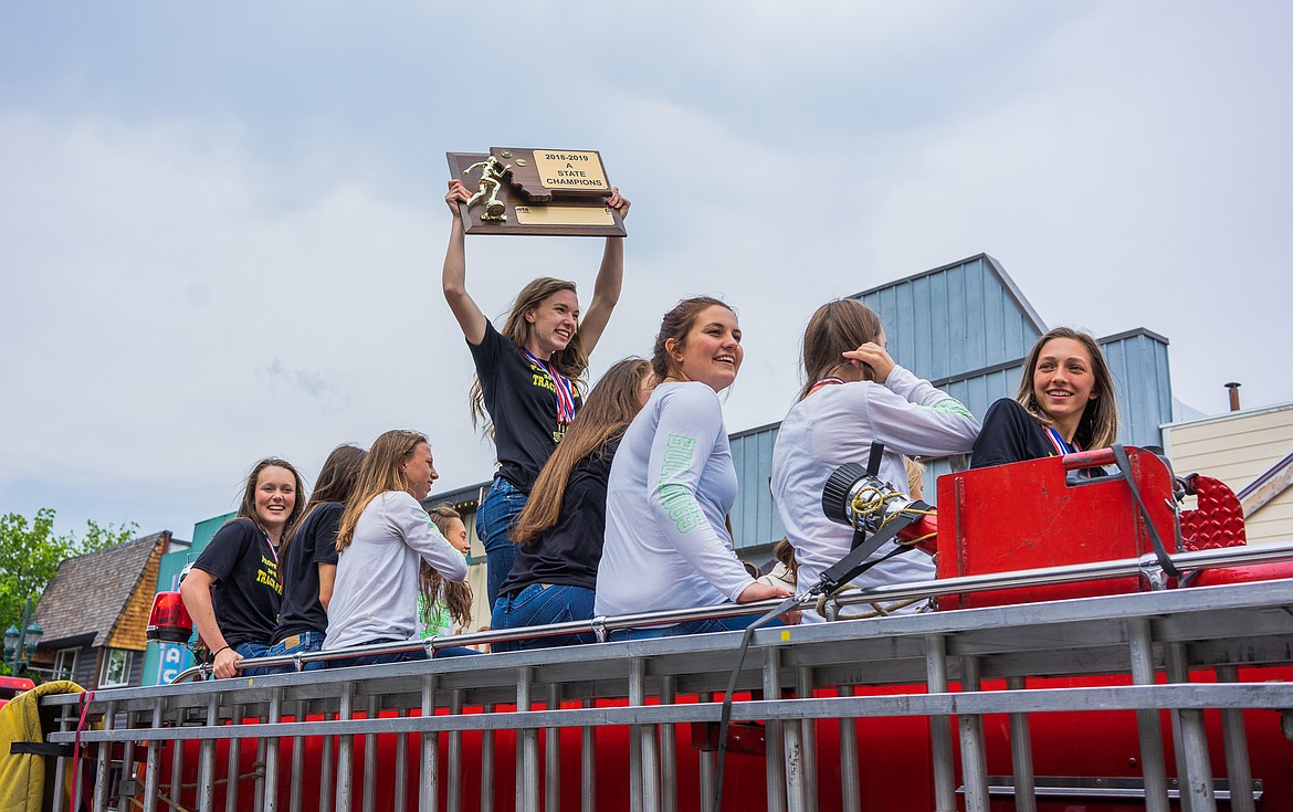 The Lady Bulldog track and field team takes its celebratory firetruck ride downtown after winning the Class A State Title last weekend. (Daniel McKay/Whitefish Pilot)