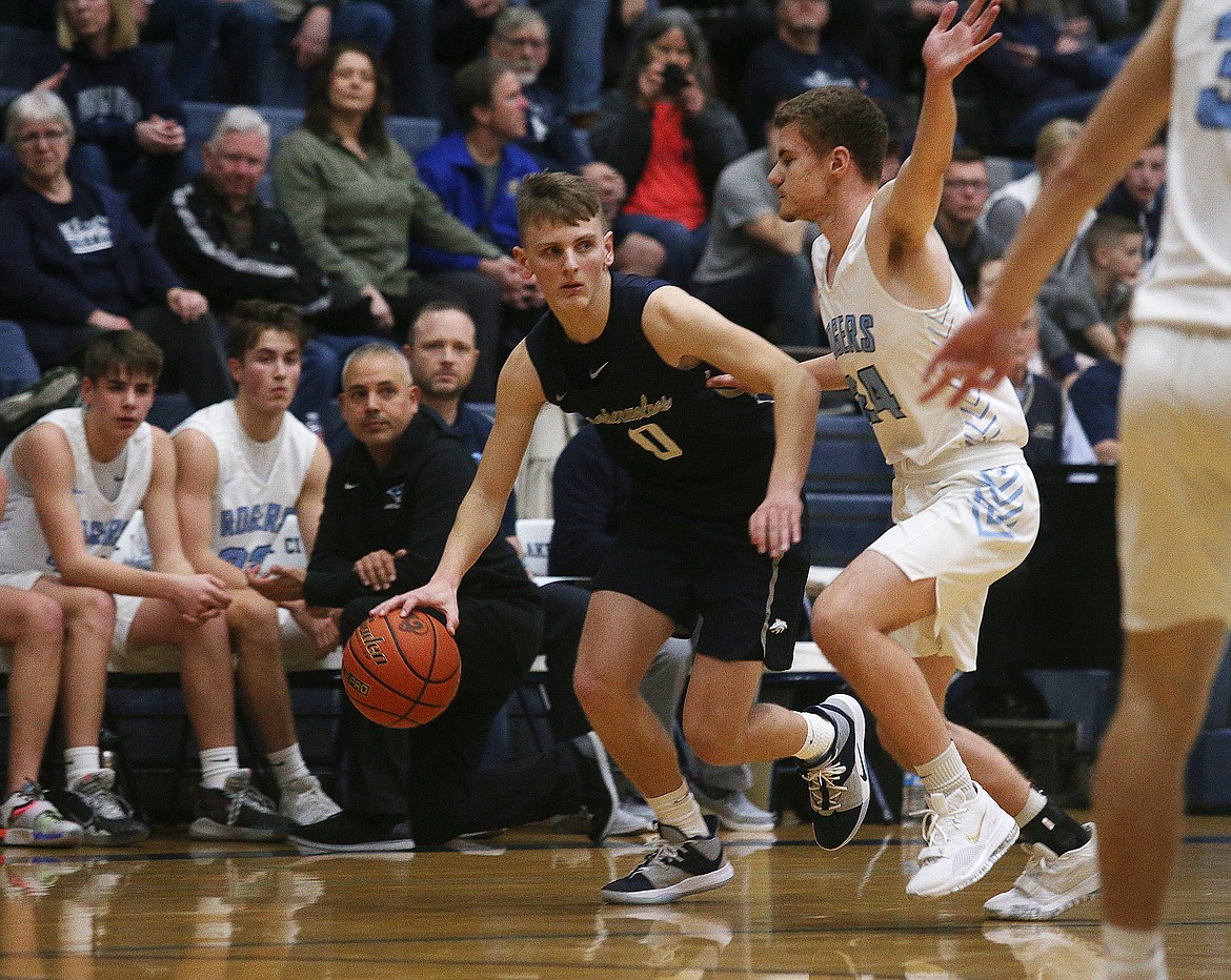 Lake City&#146;s Chris Irvin dribbles the ball around Nate Hansen from Rogers of Puyallup, Wash., in a Lake City Invitational game on Friday.