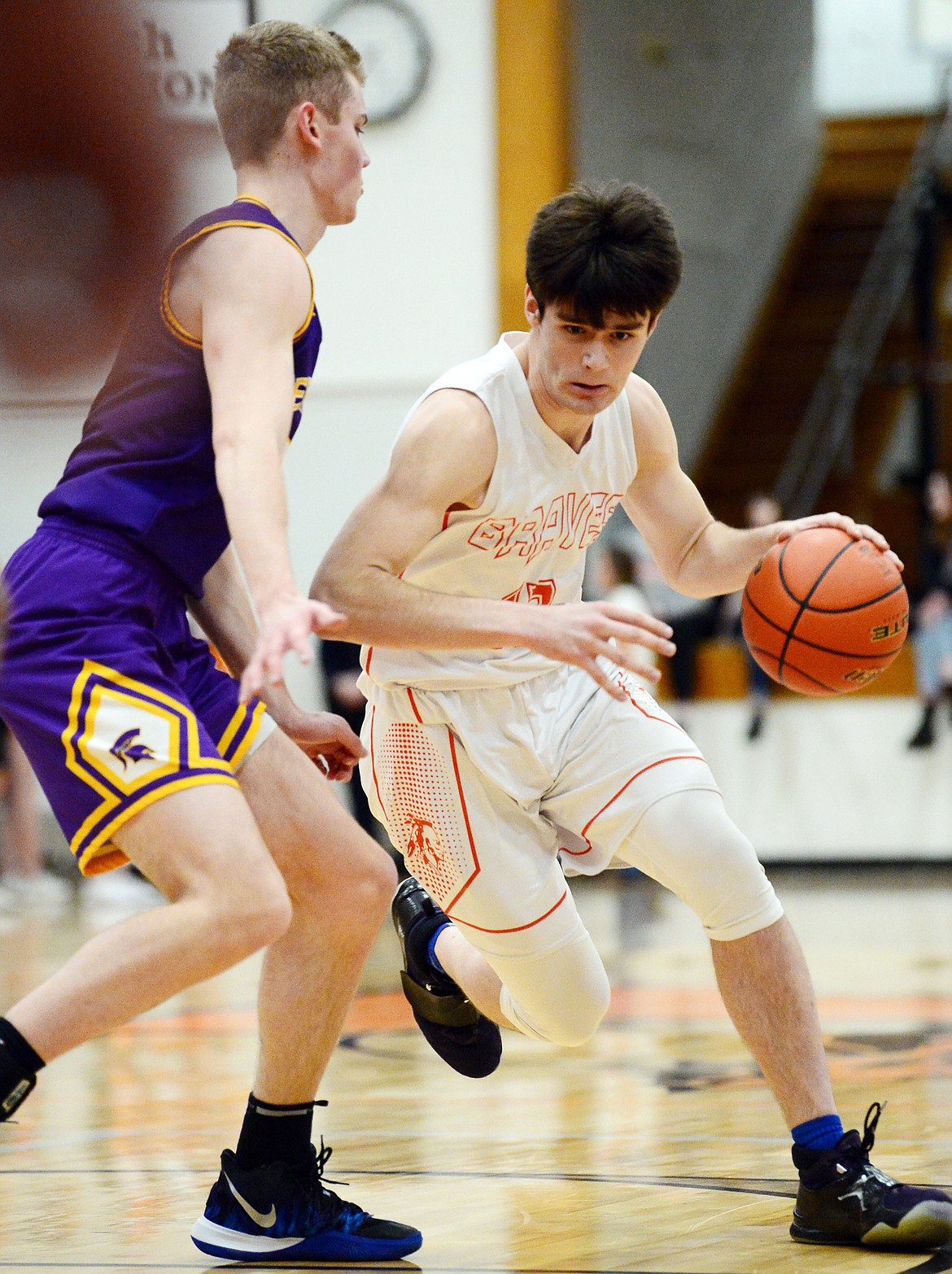 Flathead's Gabe Adams (13) drives into the lane against Missoula Sentinel's Alex Germer (5) at Flathead High School on Thursday. (Casey Kreider/Daily Inter Lake)