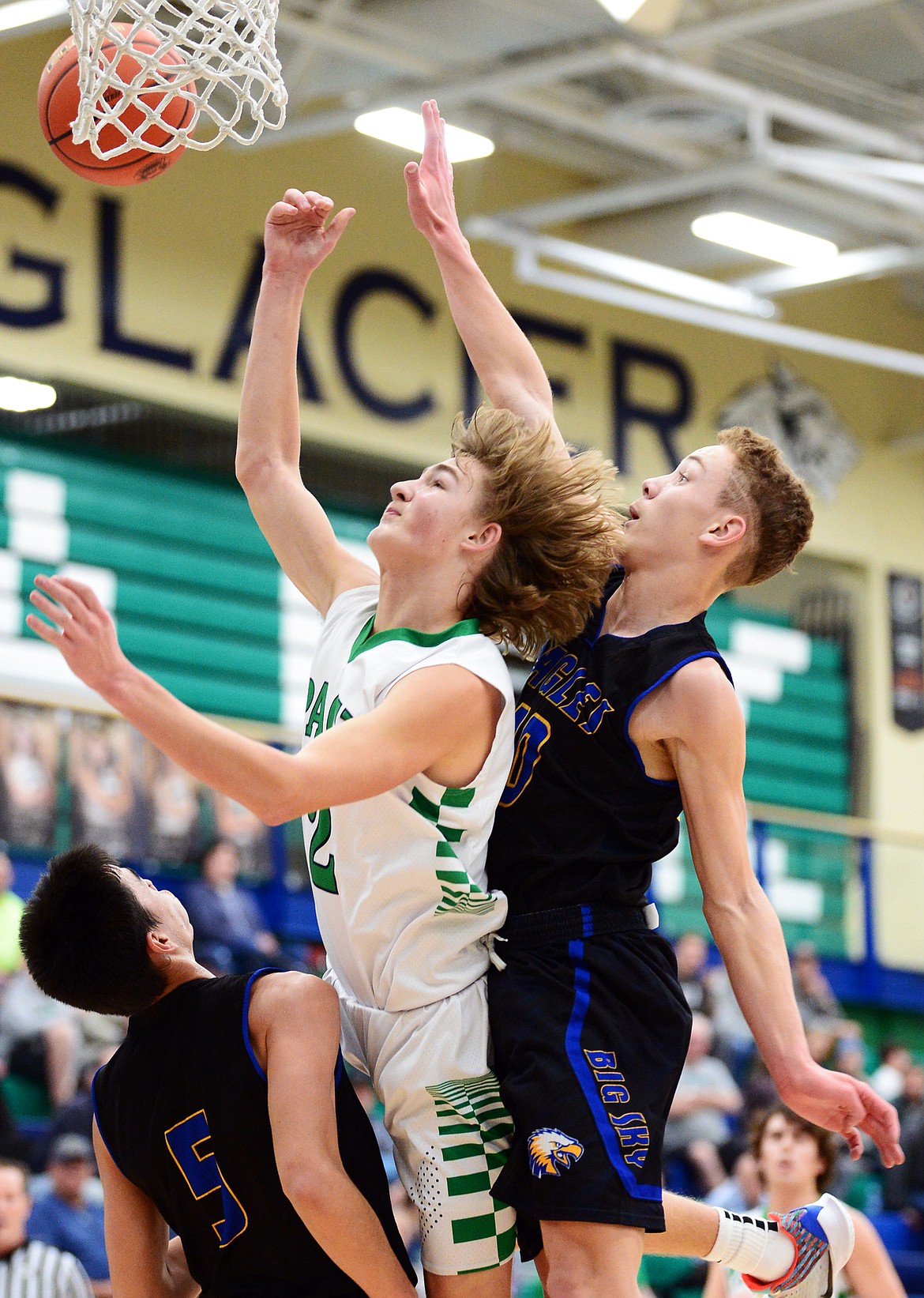 Glacier's Keifer Spohnhauer (2) drives to the basket between Missoula Big Sky's Shawn Phelps (5) and Carson Mantei (10) at Glacier High School on Tuesday. (Casey Kreider/Daily Inter Lake)