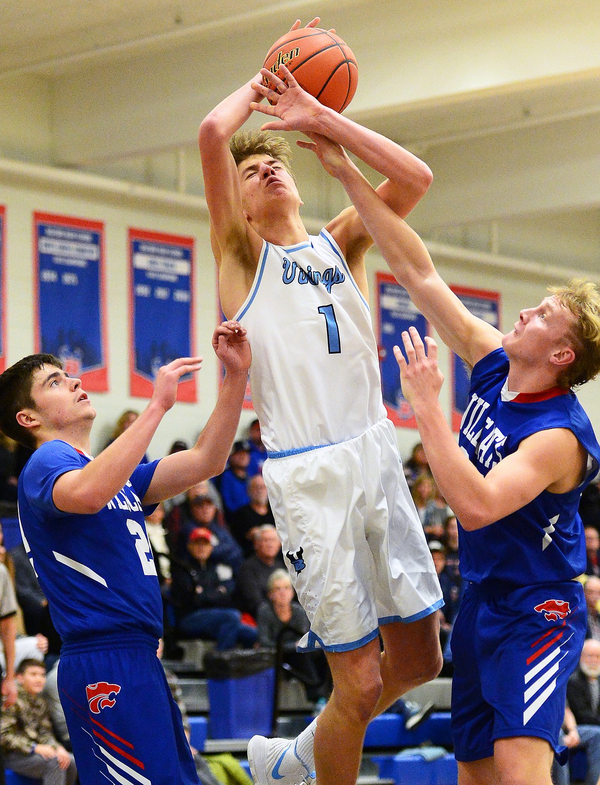 Bigfork's Colt Thorness (1) is fouled by Columbia Falls' Allec Knapton (35, right) as he goes to the hoop in the second half at Bigfork High School on Friday. At left is Columbia Falls' Dillon Shipp (24). (Casey Kreider/Daily Inter Lake)