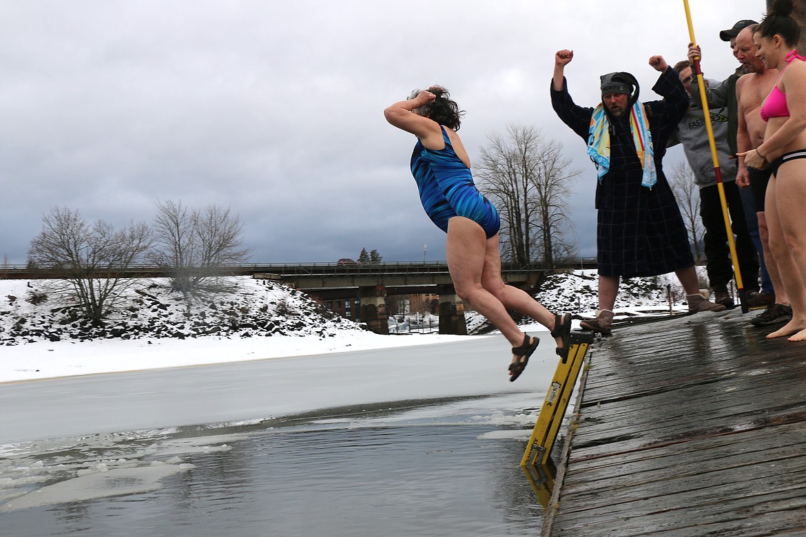 (Photo by CAROLINE LOBSINGER)
Ellen Weissman, taking part in her 18th Polar Bear Plunge leaps from the dock during Wednesday&#146;s event as Boy Scout Troop 111&#146;s scout leader Phil Voelz cheers her on.