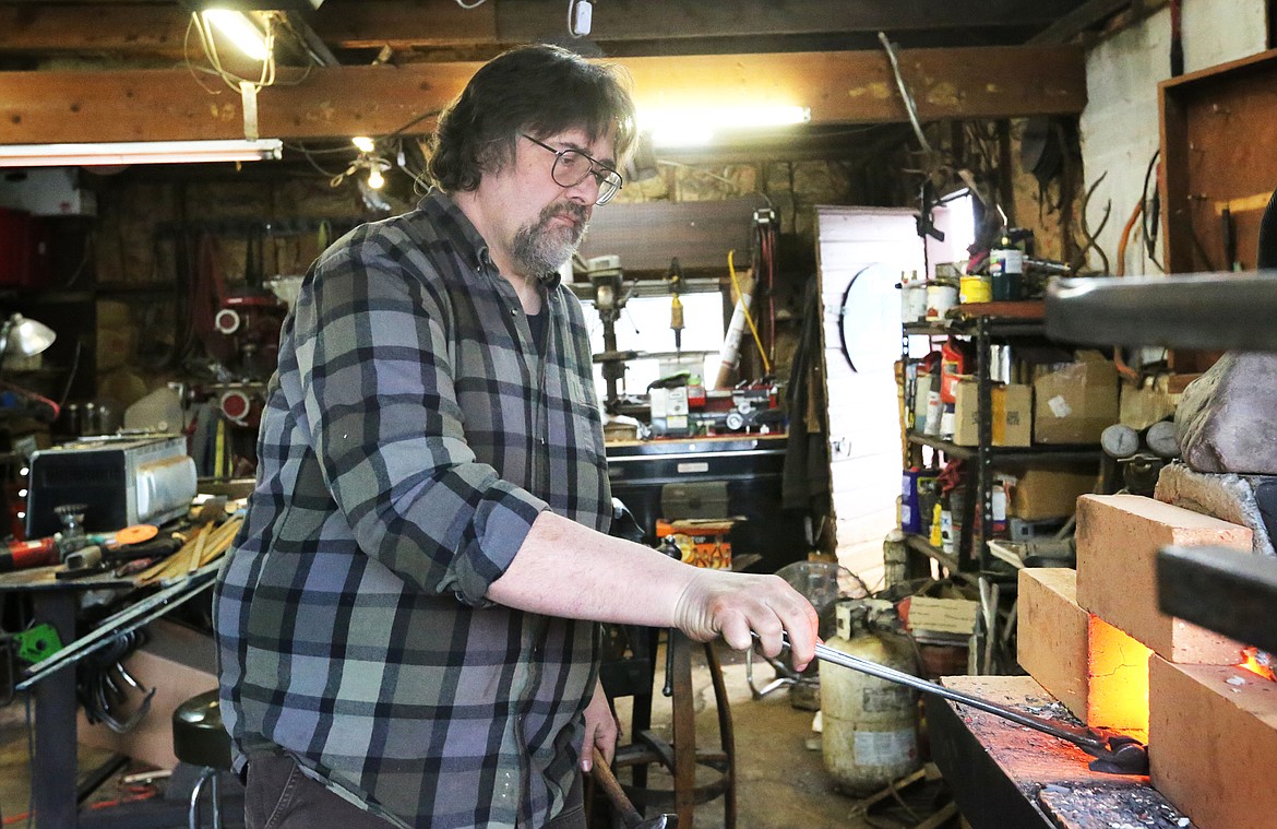 Scott Sweder heats a blade of steel at his Columbia Falls metal shop, Iron Bear Knife and Forge.