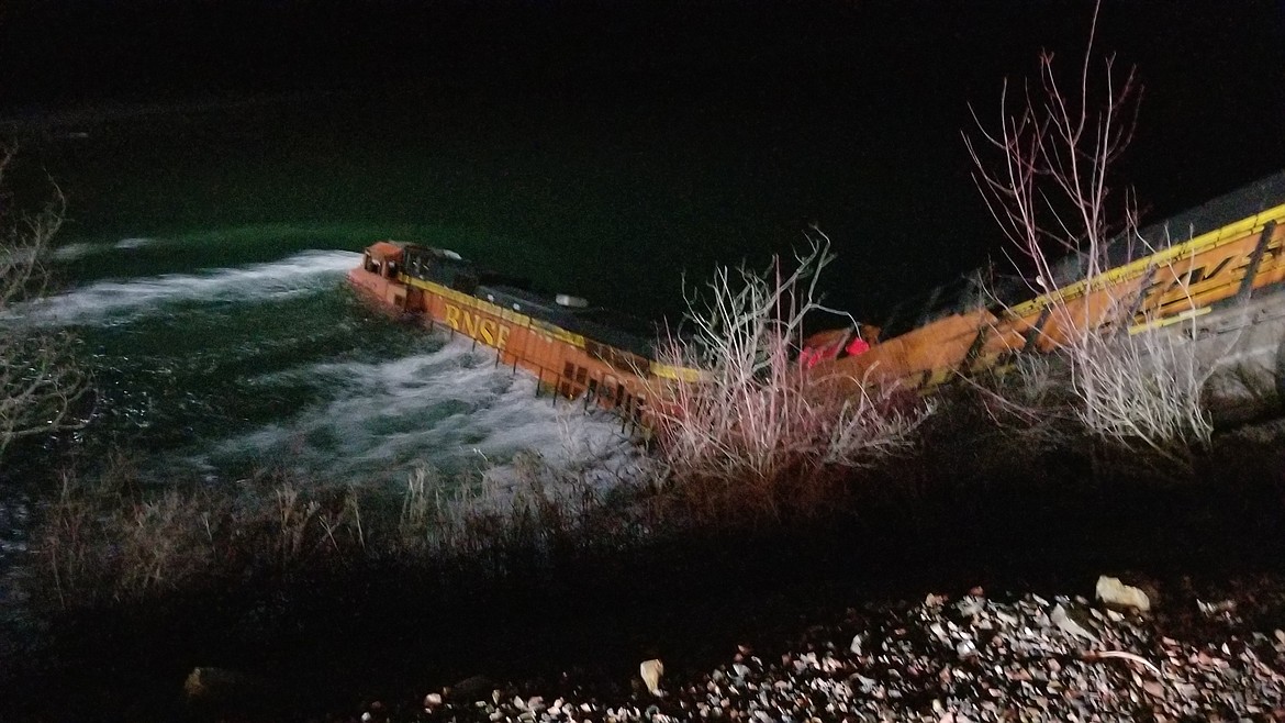 (Courtesy photo)A BNSF Railway train is buffeted by the Kootenai River after derailing late Wednesday night.