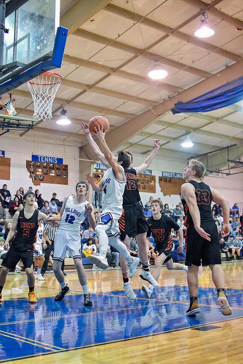 Mission Bulldog freshman guard Zoran LaFrombois (4) drives for the paint for a layup. (Photo courtesy of Christa Umphrey, Forward Photography)