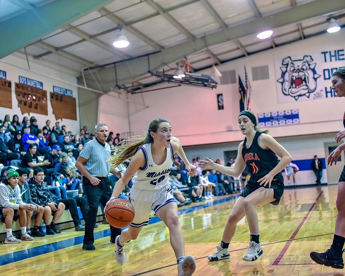 Mission Lady Bulldog junior Sydney Brander (24) dribble drives toward the basket. (Photo courtesy of Christa Umphrey, Forward Photography)