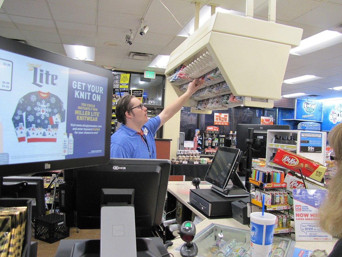 Jonne Larsen, at Holiday, grabs a pack of smokes for a customer.