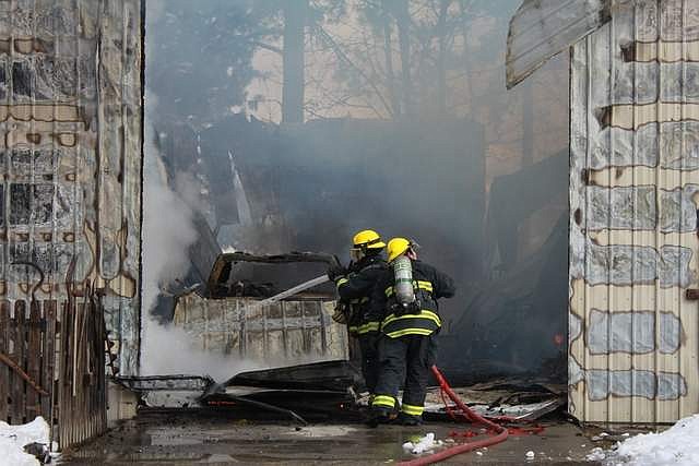 Photo by TANNA YEOUMANS
North Bench Firefighters battle a blaze that demolished two vehicles and a tractor that were parked in a shop on Bench Road on Feb. 18.