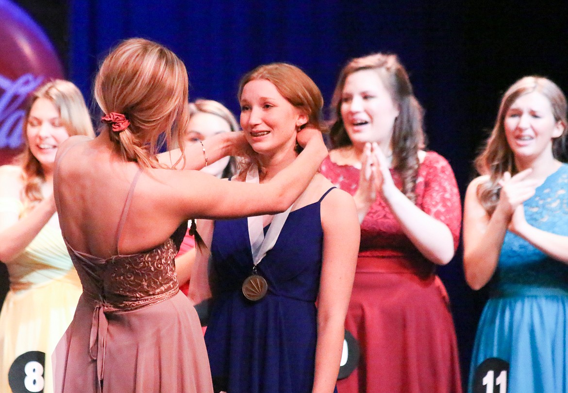 Photo by MANDI BATEMAN
Distinguished Young Woman, 1st Runner Up 2018-2019 Jerzie Pluid places the Official DYW Medallion on Katie Summerfield, the 2019-2020 Distinguished Young Woman, at the end of the program on April 27.