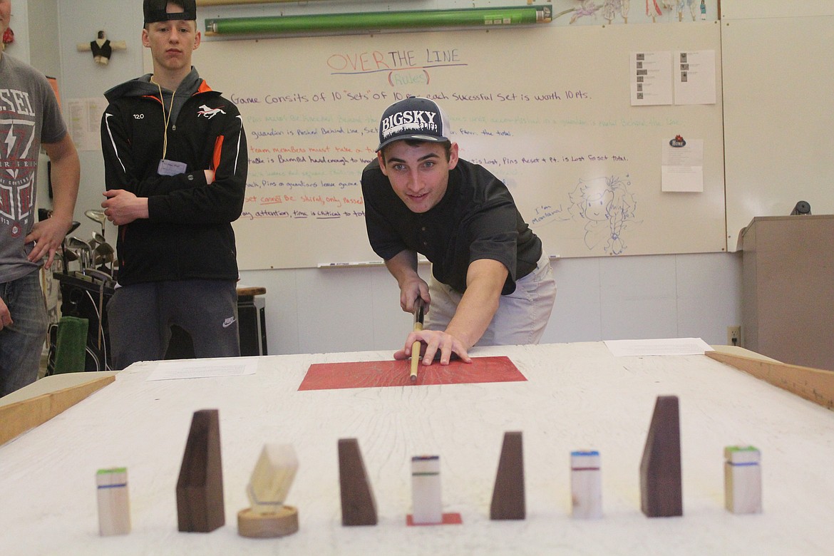 JEREMIAH ALLEN trying his luck with a slide-board-style game. He was part of the professional golfers team last week during Plains High&#146;s Brain Bash. (John Dowd/Clark Fork Valley Press)