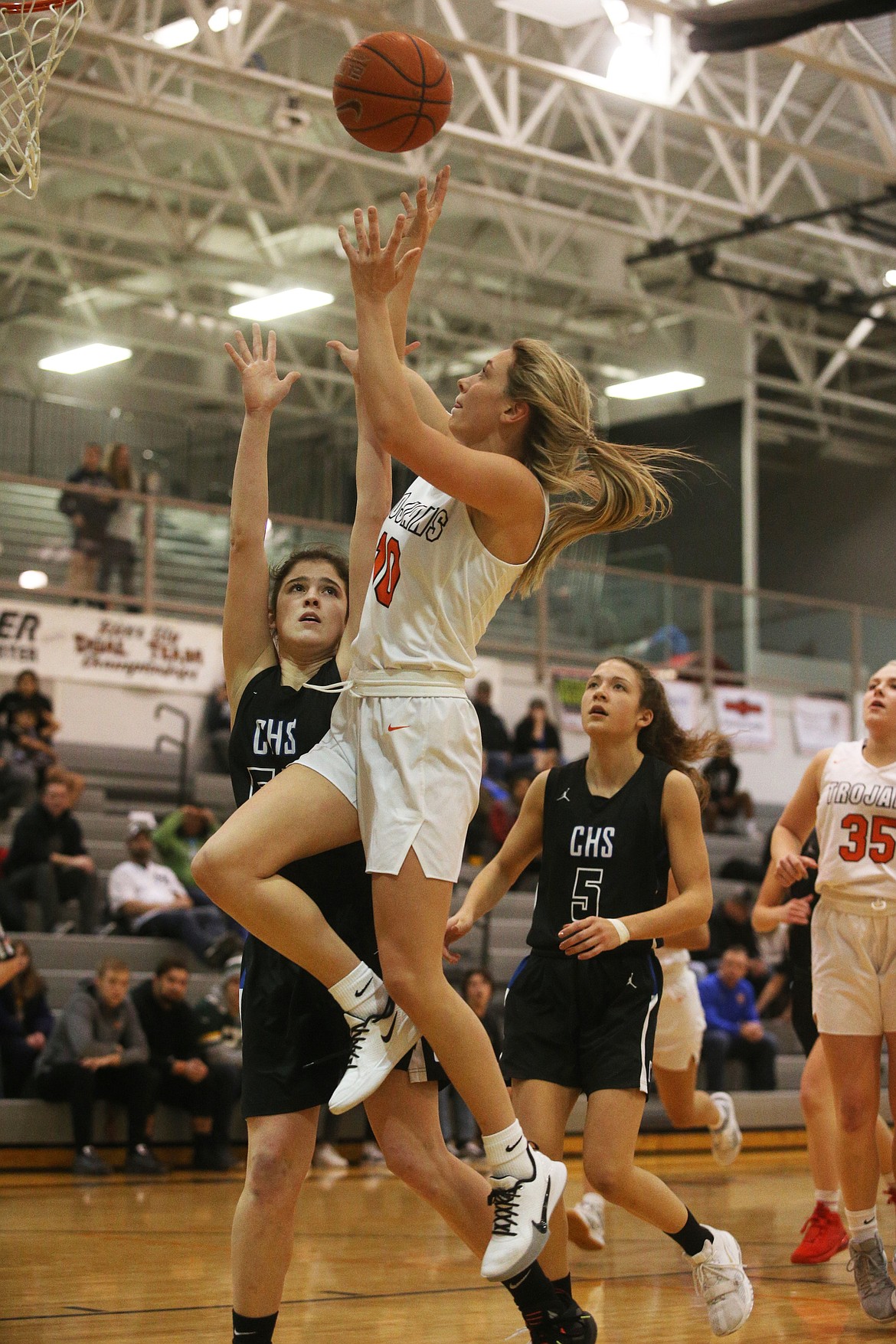 Post Falls' Dylan Lovett scores on a layup while defended by Coeur d'Alene's Skylar Burke. (LOREN BENOIT/Press)
