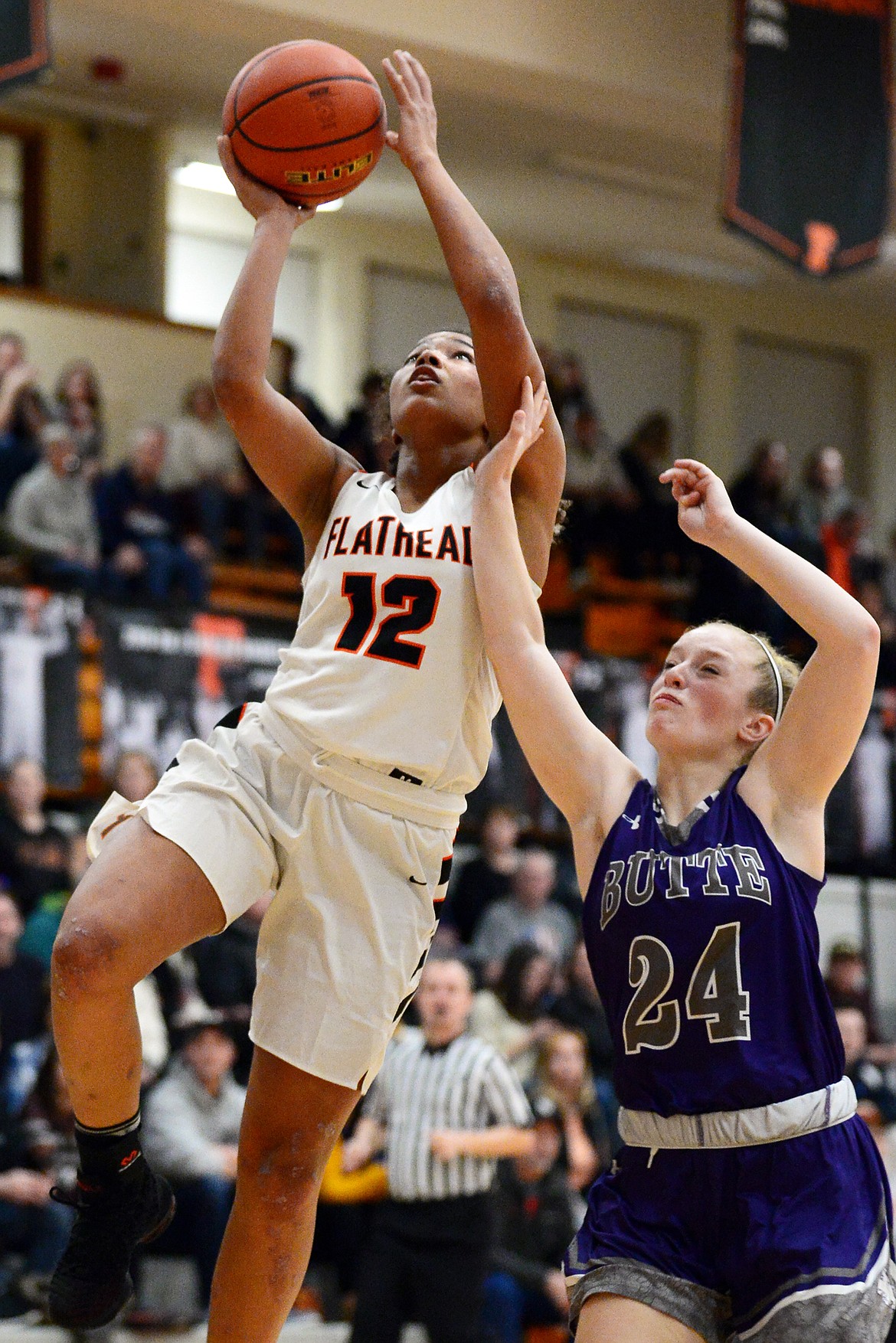 Flathead's Akilah Kubi (12) drives to the hoop in front of Butte's Trisha Ericson (24) at Flathead High School on Friday. (Casey Kreider/Daily Inter Lake)