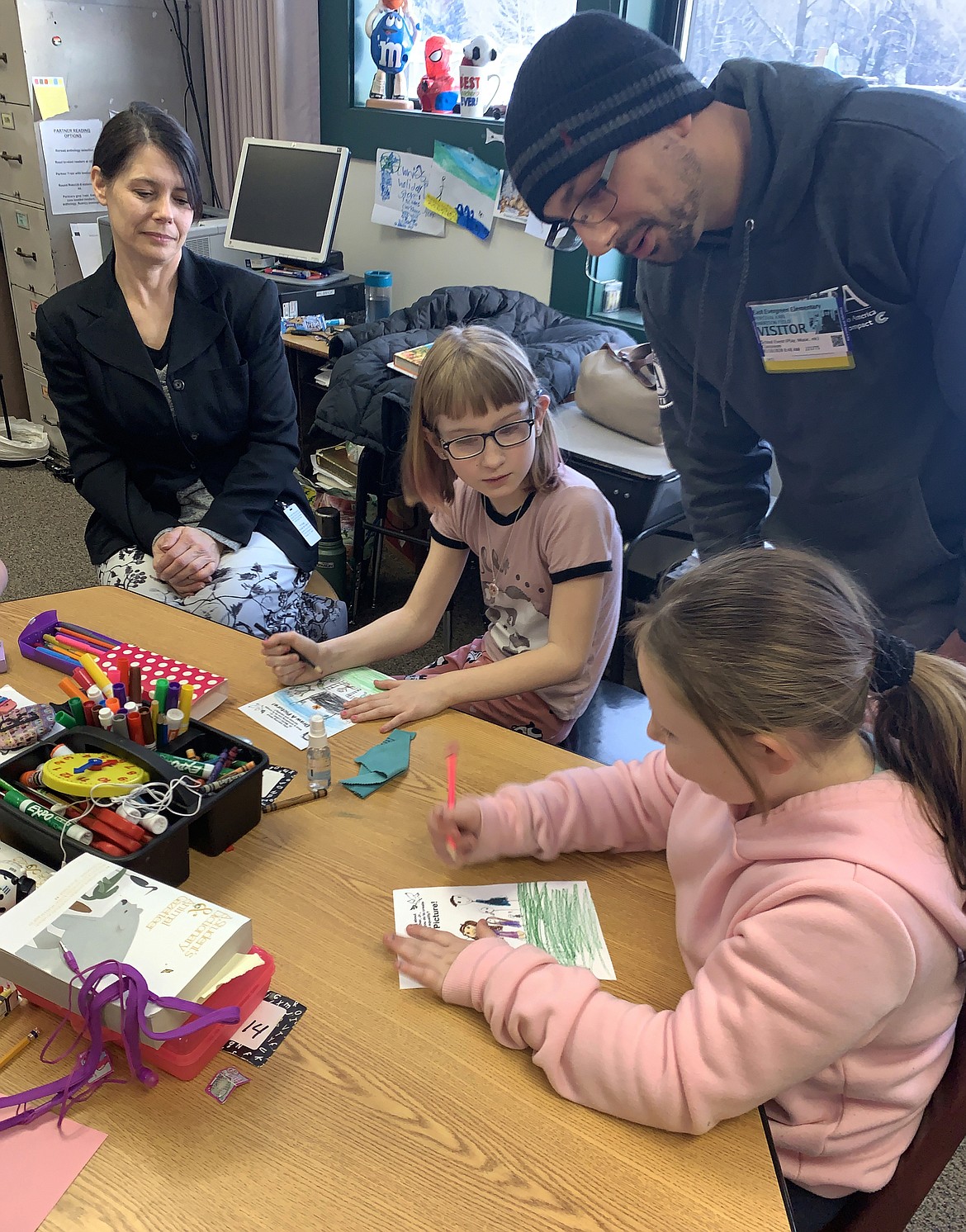 East Evergreen Elementary third-graders Jenasee Lolley, right, and Braylynne Clarke, left, share their drawings on the topic &#147;what is something you do to create fairness and equality,&#148; to AmeriCorps VISTA member Percival Field as part of Montana Campus Compact&#146;s &#147;MLK Read for Peace&#148; event on Thursday, Jan. 16.