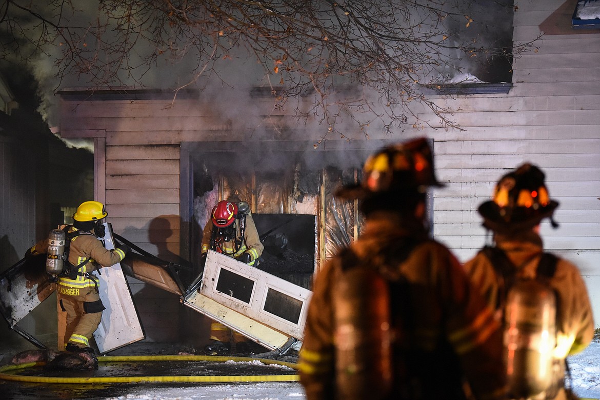 Firefighters work at the scene of a house fire in the 1200 block of 4th Avenue East in Kalispell on Wednesday night.