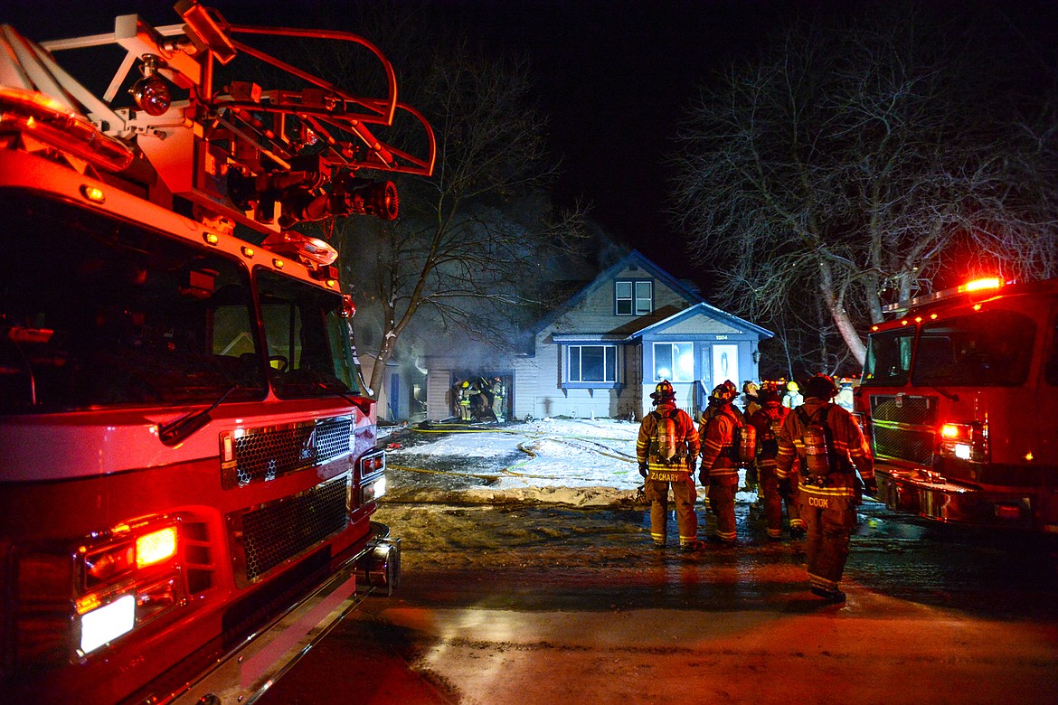 Firefighters work at the scene of a house fire in the 1200 block of 4th Avenue East in Kalispell on Wednesday night. (Casey Kreider/Daily Inter Lake)