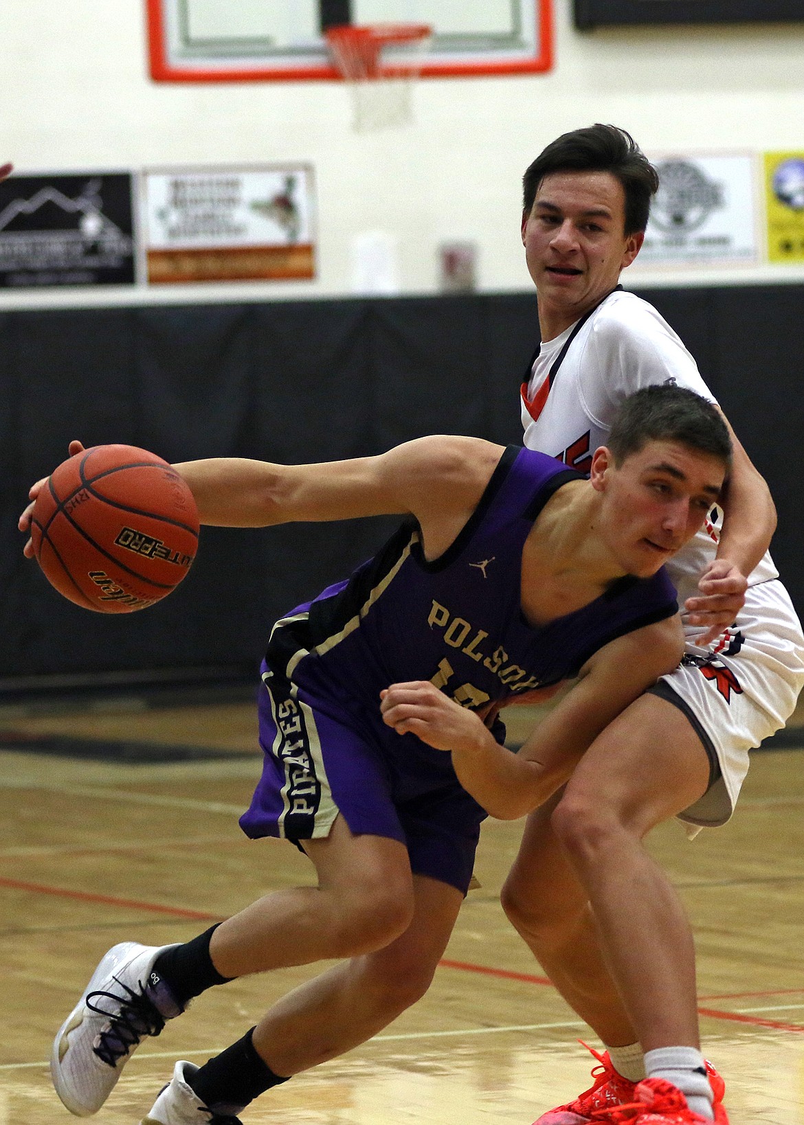 Polson senior guard Ryker Wenderoth drives by a Ronan defender Friday night in Ronan. (Bob Gunderson photo)